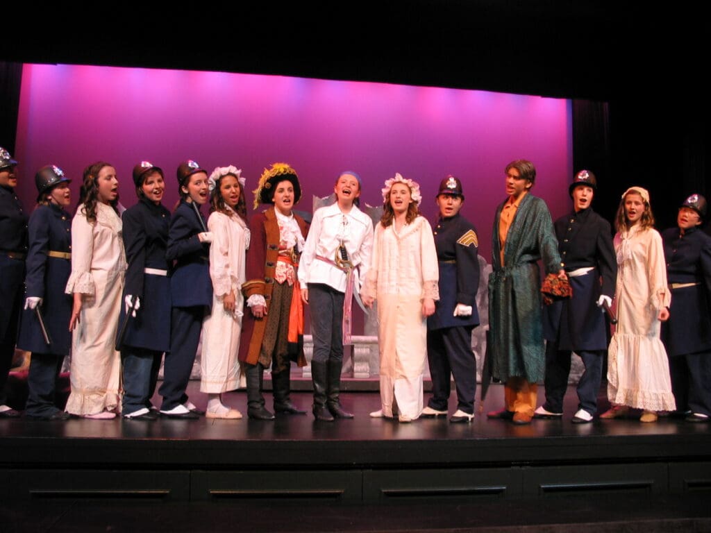 A group of people on stage in front of purple lights.